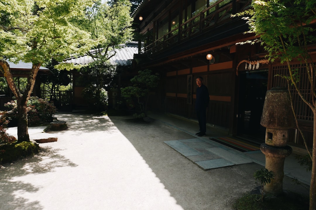 man-standing-outside-brown-wooden-building-at-daytime-btmaamtwl8k